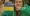 Mariia in green feathers, with a Ukrainian flag