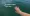 Mariia's hand, nails painted in berry red, against the lake.